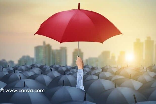 Ein einzelner Mensch hält einen roten Regenschirm über einer Menge schwarzer Regenschirme in einer urbanen Umgebung. Positionierung ist wichtig.